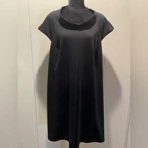 Black knit dress with from pleat. Stand up shawl type collar